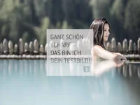 Frau entspannt am Rand eines Pools, unscharfer Hintergrund mit Bäumen und Zaun