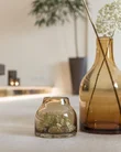 Zwei braune Glasvasen mit weißen Blumen auf einem Tisch in einem Wohnzimmer