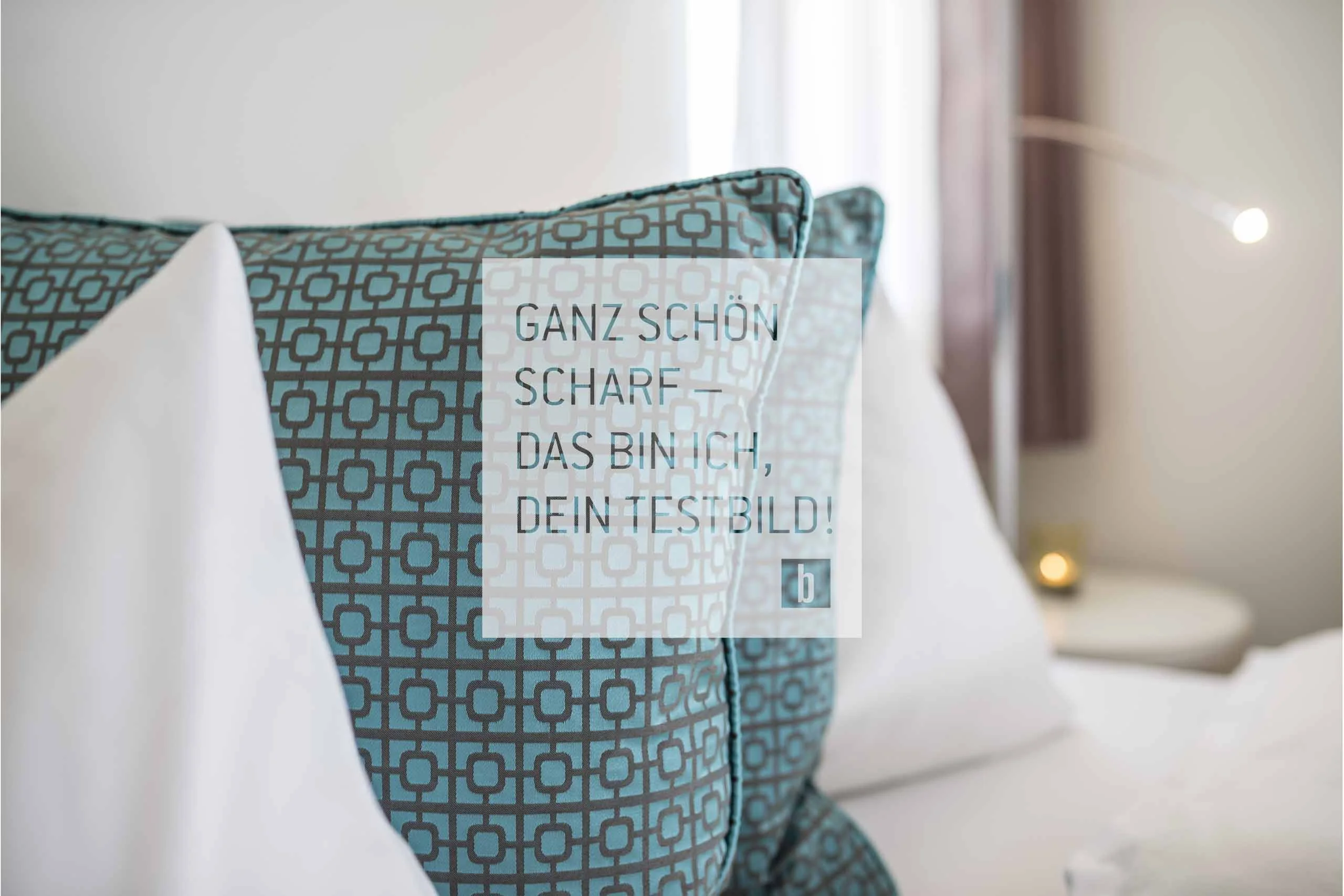 Beispielaufbau einer Unterseite Blau gemusterte Kissen auf einem weißen Bett mit Textoverlay in einem Raum