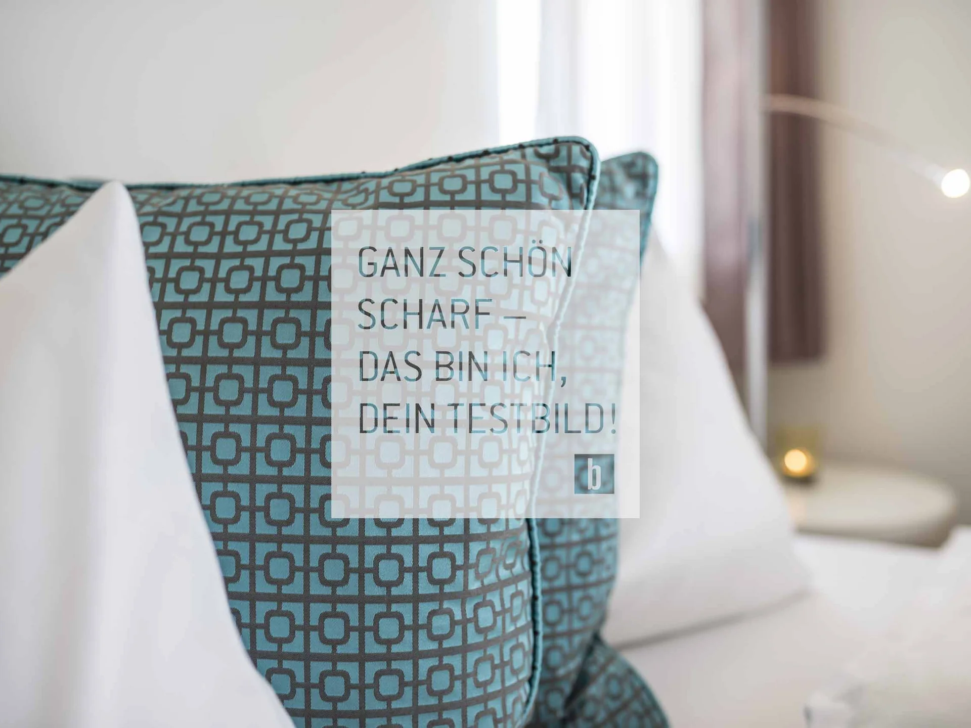 Blau gemusterte Kissen auf einem weißen Bett mit Textoverlay in einem Raum