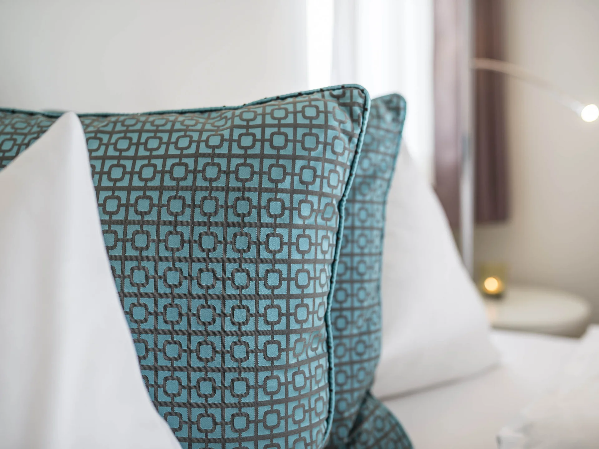Beispielaufbau einer Unterseite Blau gemusterte Kissen auf einem weißen Bett mit Textoverlay in einem Raum