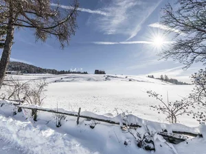 Schneebedeckte Landschaft mit Sonne und blauem Himmel