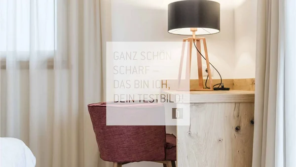 Rotes Stuhl vor Holztisch mit schwarzer Lampenschirmlampe in einem hellen Raum