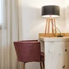 Rotes Stuhl vor Holztisch mit schwarzer Lampenschirmlampe in einem hellen Raum