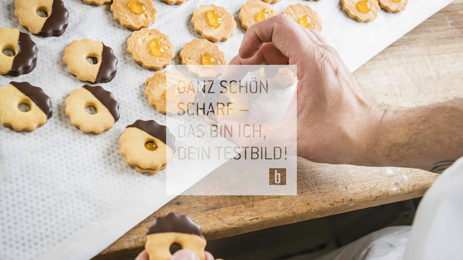 ALLE INHALTSELEMENTE Person legt frisch gebackene Kekse mit Marmelade und Schokolade auf Backpapier