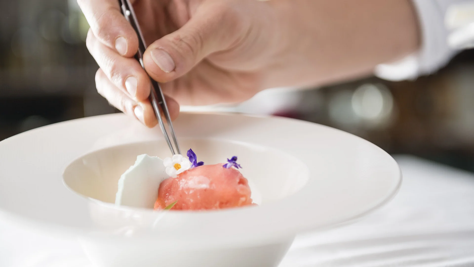 Person legt frisch gebackene Kekse mit Marmelade und Schokolade auf Backpapier