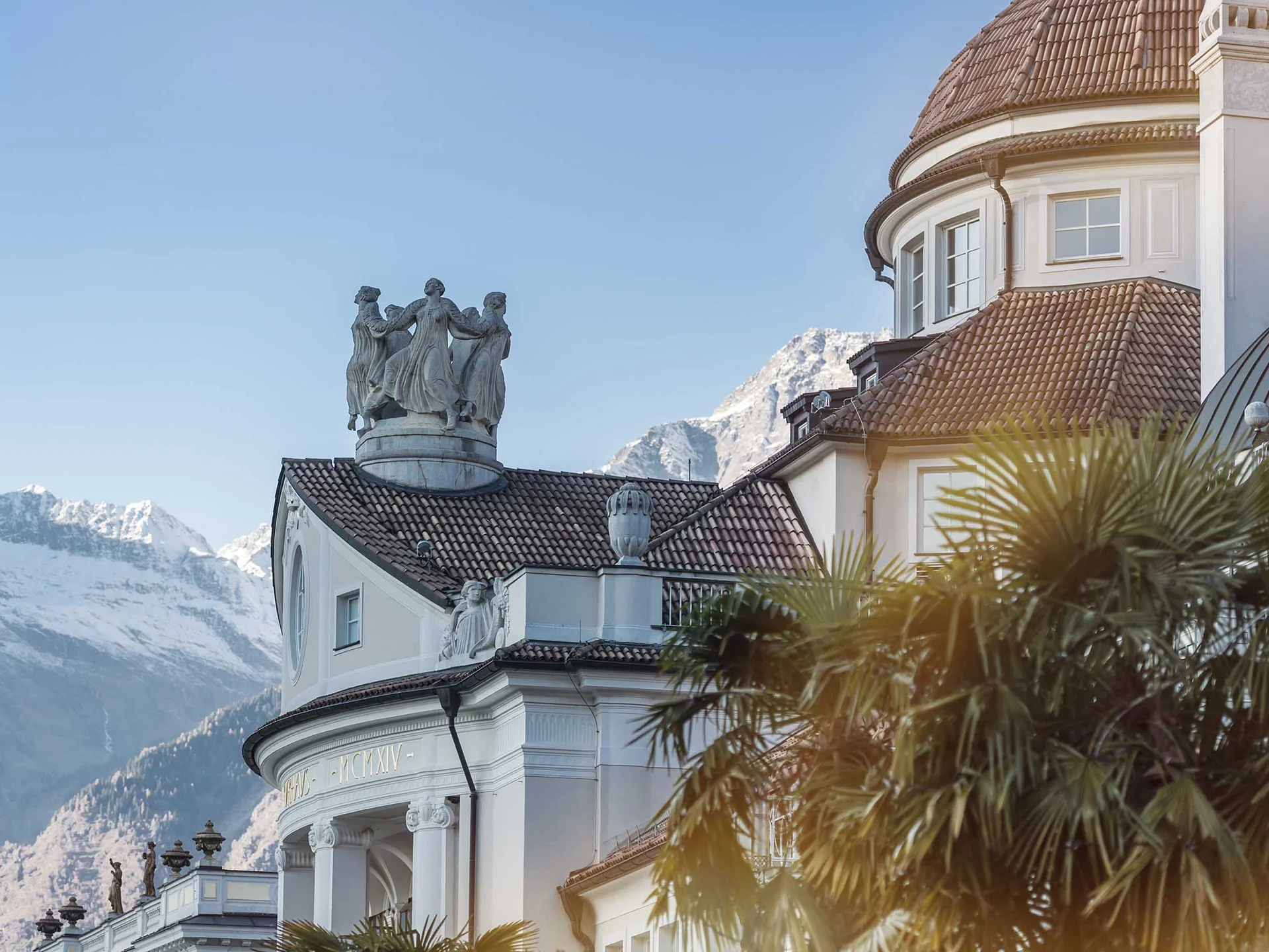 Beispielaufbau einer Unterseite Historisches Gebäude und schneebedeckte Berge im Hintergrund bei klarem Himmel