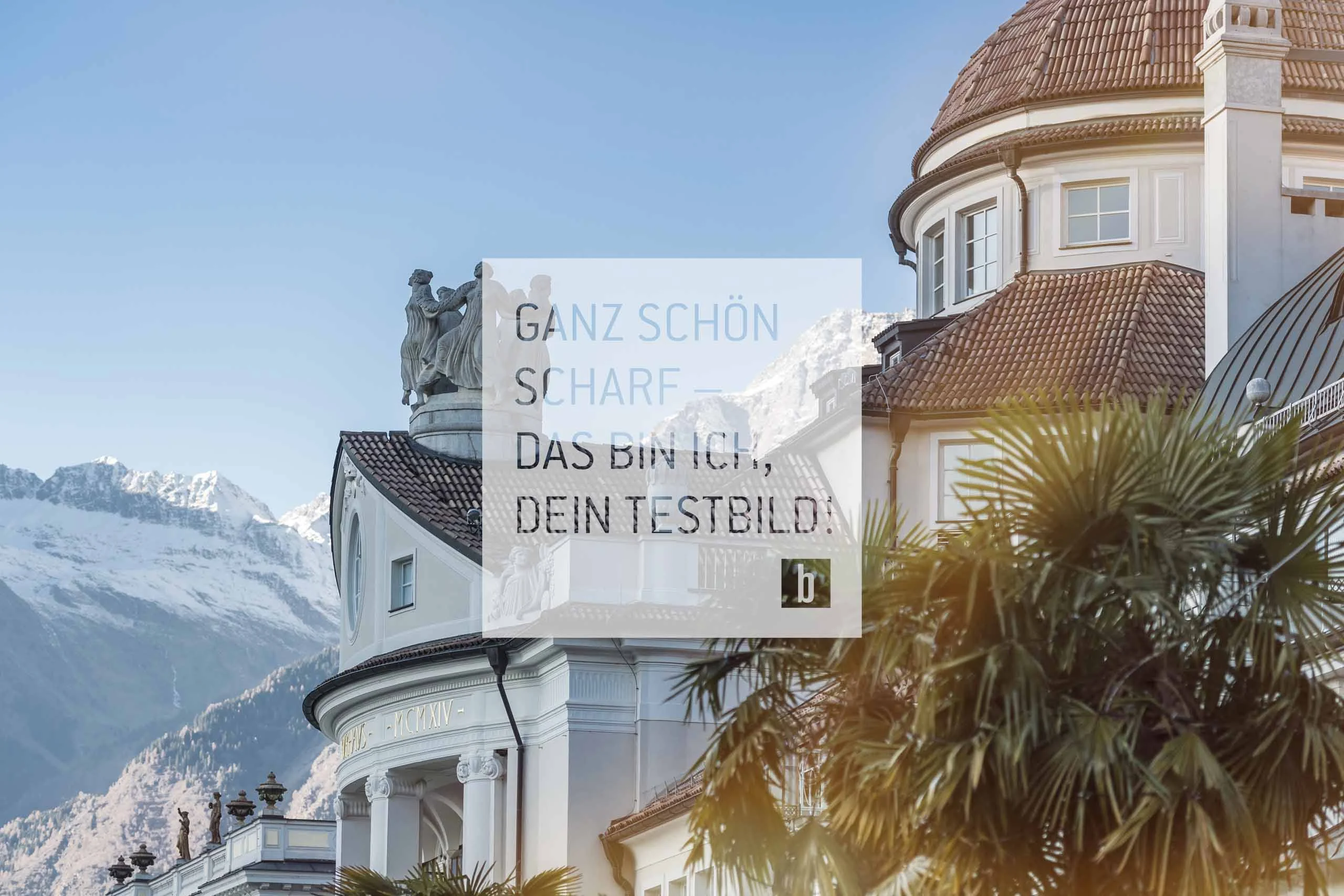 Beispielaufbau einer Unterseite Historisches Gebäude und schneebedeckte Berge im Hintergrund bei klarem Himmel