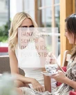 Food Zwei Frauen trinken Kaffee draußen in einem Café und unterhalten sich
