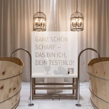 Zwei Holzwannen mit Wasserhähnen und zwei hängende Metalllampen vor Vorhang