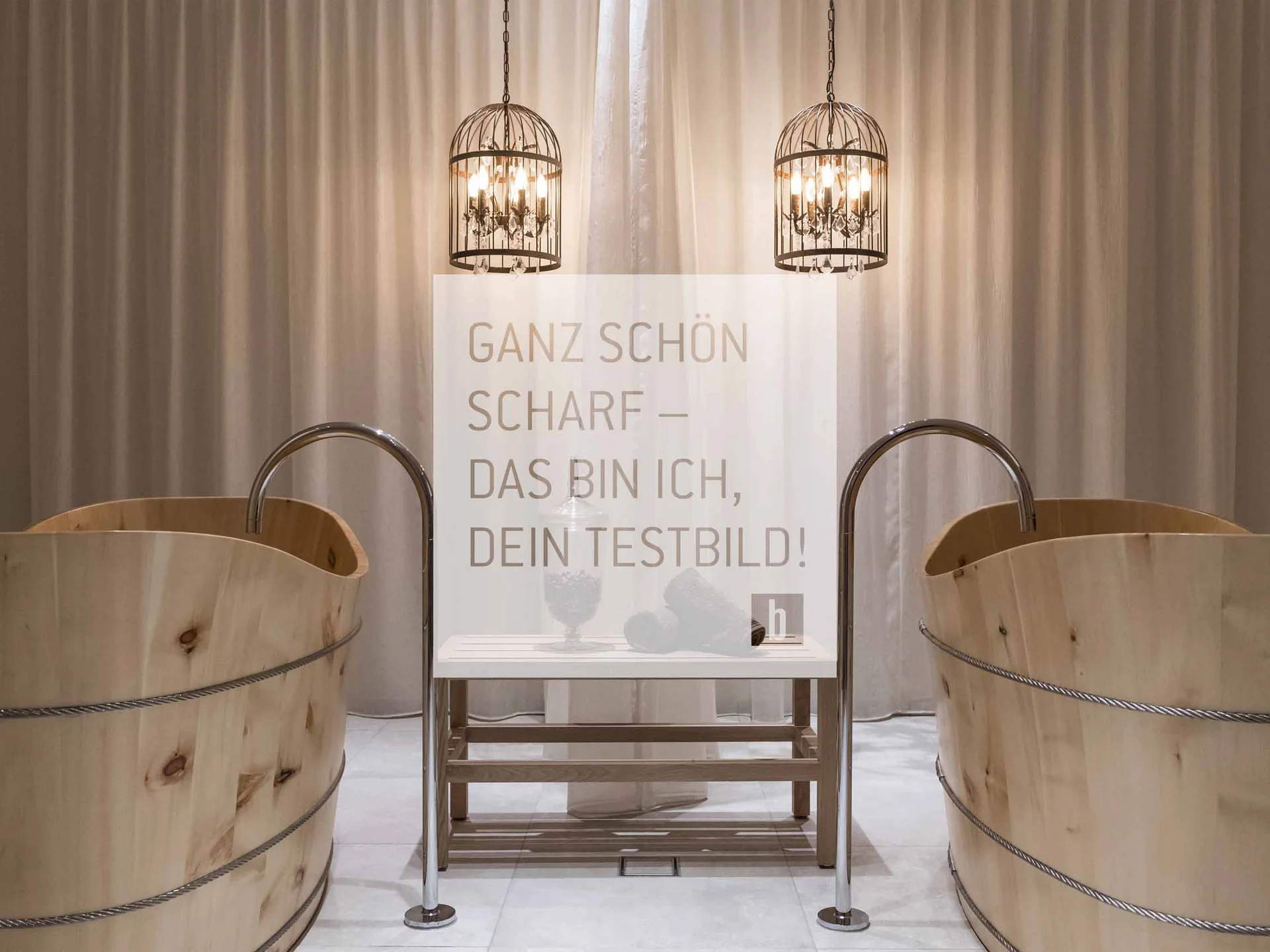 Two wooden tubs with faucets and two hanging metal lights in front of curtain