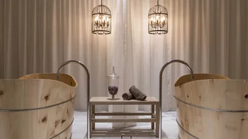 Zwei Holzwannen mit Wasserhähnen und zwei hängende Metalllampen vor Vorhang