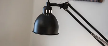 Schwarze verstellbare Schreibtischlampe vor unscharfem Hintergrund