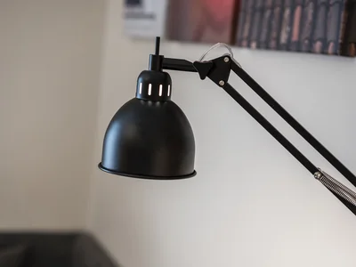 Schwarze verstellbare Schreibtischlampe vor unscharfem Hintergrund