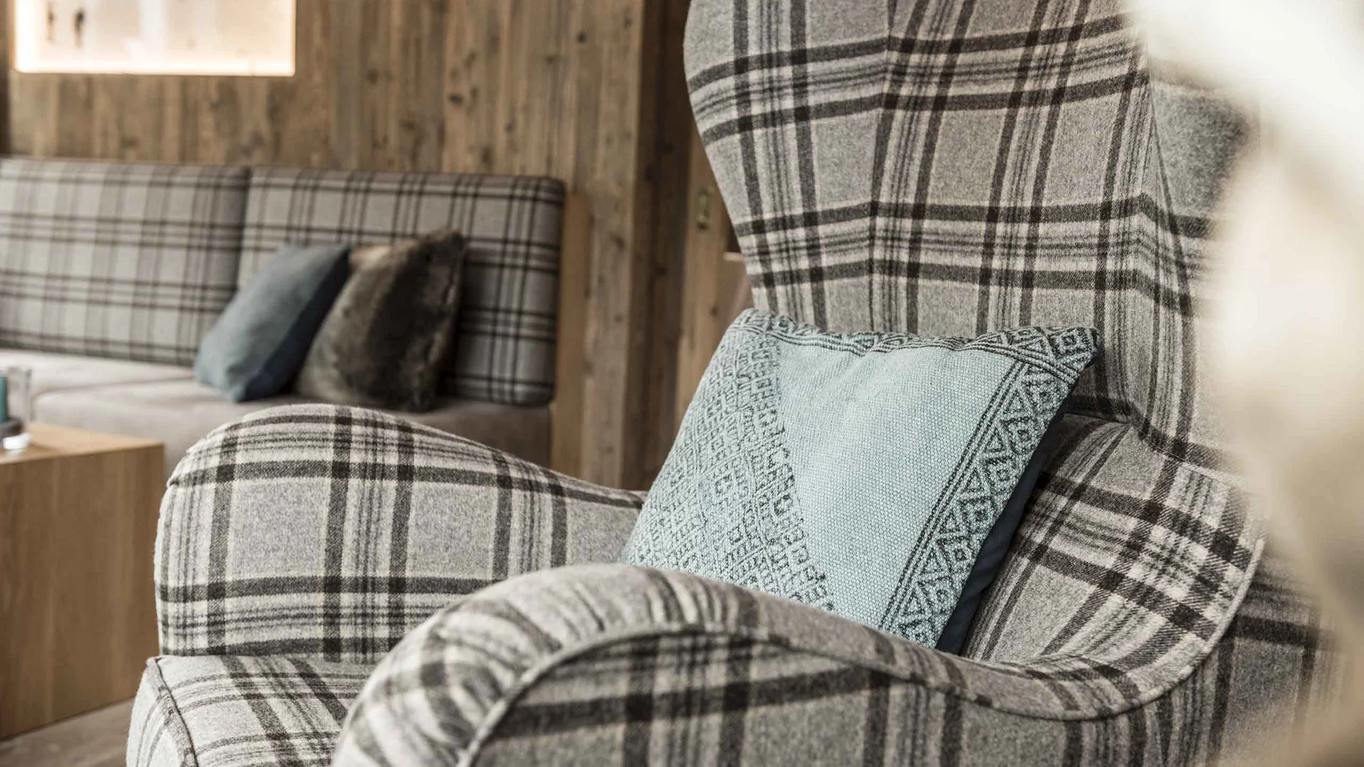 Gemütlicher Sessel mit kariertem Stoff und Zierkissen in modernem Wohnzimmer