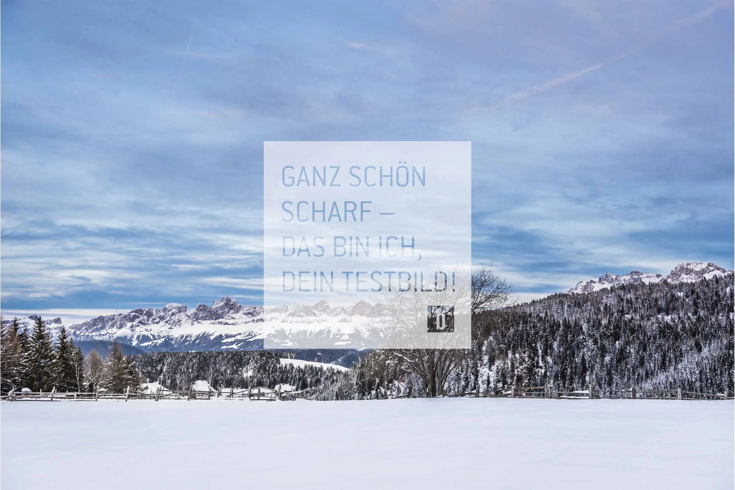 Schneebedeckte Landschaft mit Bergen, Bäumen und blauem Himmel
