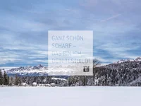 Schneebedeckte Landschaft mit Bergen, Bäumen und blauem Himmel