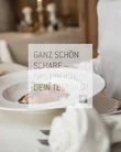 Food Person sitzt am gedeckten Tisch mit Teller und Weinglas im Restaurant