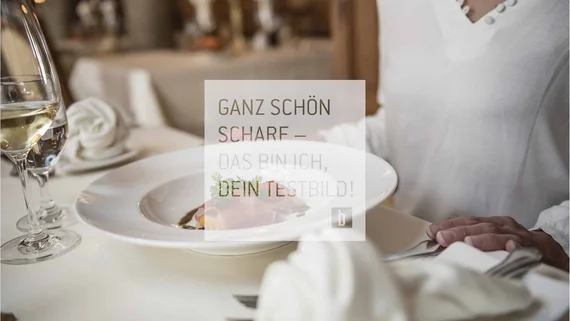 Food Person sitzt am gedeckten Tisch mit Teller und Weinglas im Restaurant