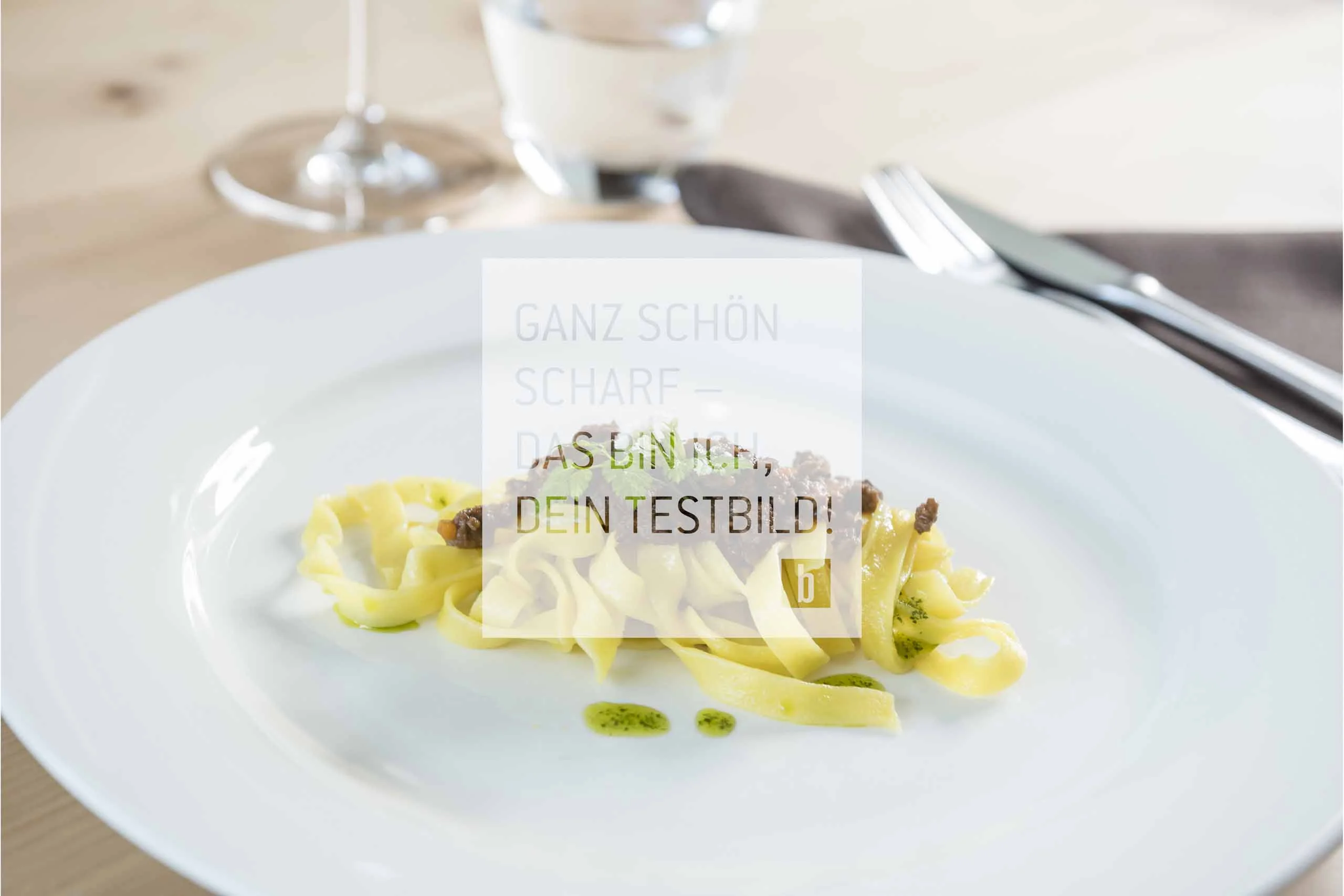 Beispielaufbau einer Unterseite Teller mit kleinen Portion Tagliatelle und Fleischsoße garniert mit Kräutern