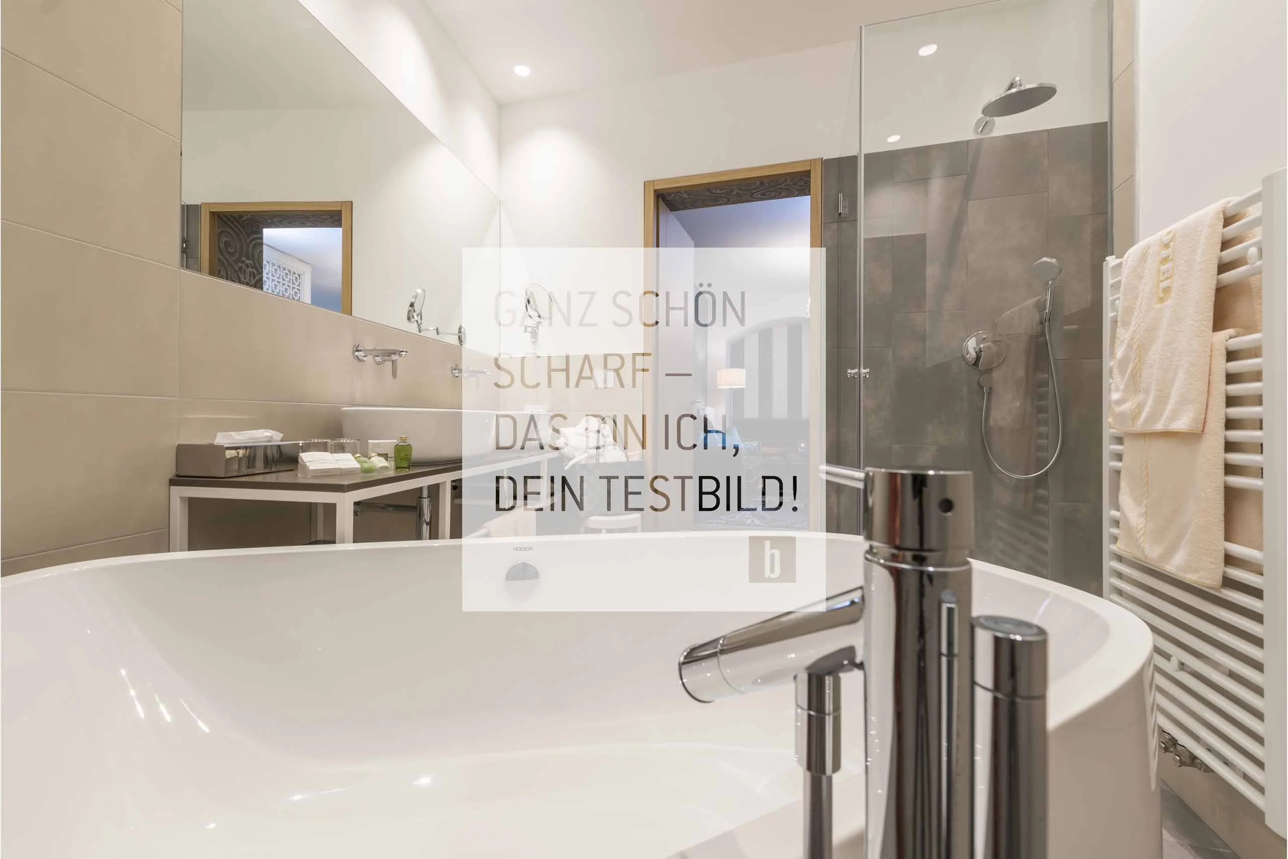 Moderner Badezimmerbereich mit Badewanne, Dusche und Handtüchern