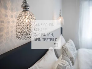 Room Moderne Kristallwandleuchte über einem gemütlichen Schlafzimmer mit Kissen
