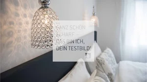 Room Moderne Kristallwandleuchte über einem gemütlichen Schlafzimmer mit Kissen