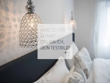 Room Moderne Kristallwandleuchte über einem gemütlichen Schlafzimmer mit Kissen